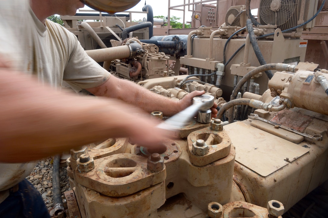 U.S. Air Force Staff Sgt. David Moseley repairs the pump mechanism on a drilling rig at the well site in Honduras Aguan, Honduras, July 10, 2015. Moseley is a vehicle maintenance journeyman assigned to the 823rd Expeditionary Red Horse Squadron.