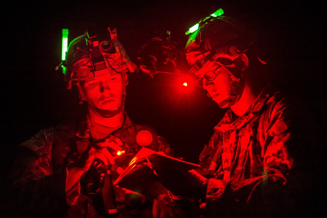 Army Reserve Cpls. Brock O'Shaughnessy and James Farran find locations on the map before a night land navigation course during Sapper Leader Course Prerequisite Training through the hills of Camp San Luis Obispo, Calif., July 15, 2015. O'Shaughnessy and Farran are combat engineers assigned to 374th Engineer Company.