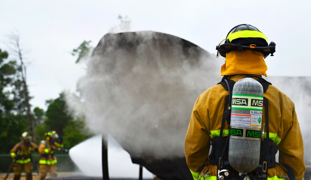 Firefighters spray water during an aircraft rescue and fire burn to