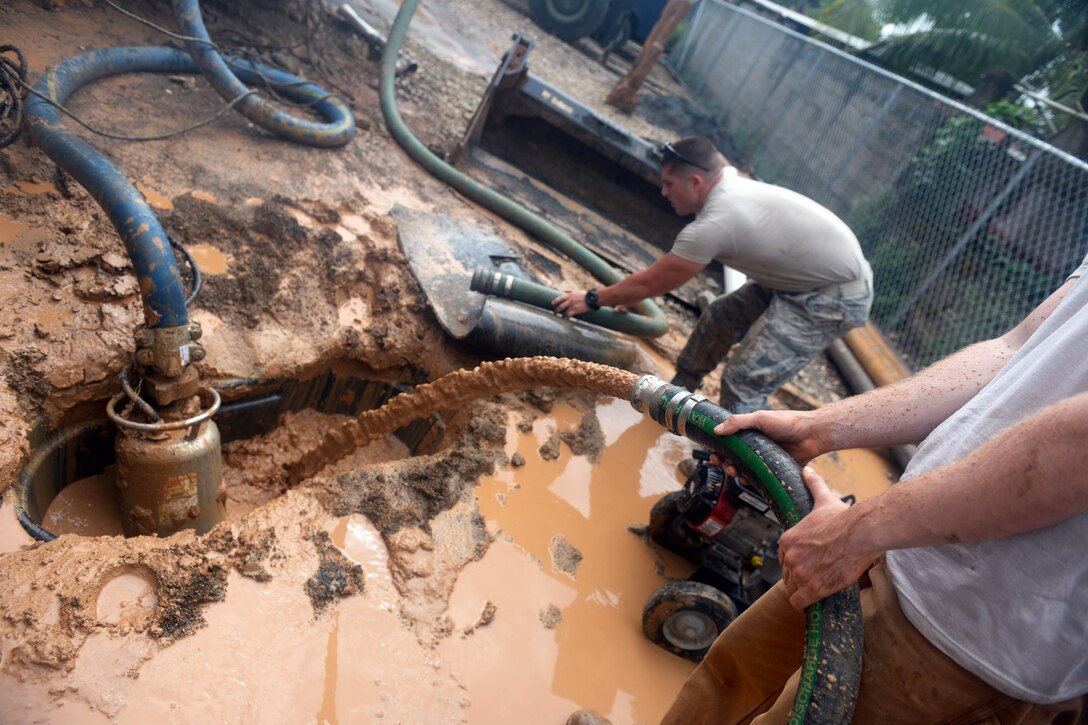 U.S. Air Force Staff Sgt. Zacharia Blower aims excess water into the drilling fluid basin at the well site in the village of Honduras Aguan near Trujillo, Honduras, July 10, 2015. Blower is a pavements and construction equipment operator assigned to the 823rd Expeditionary Red Horse Squadron.