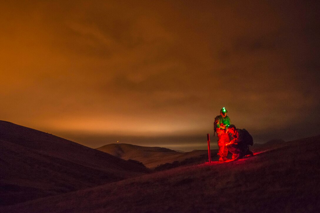 Army Reserve Cpls. Brock O'Shaughnessy and James Farran find the first point during a night land navigation course, part of Sapper Leader Course Prerequisite Training, through the hills of Camp San Luis Obispo, Calif., July 15, 2015. 