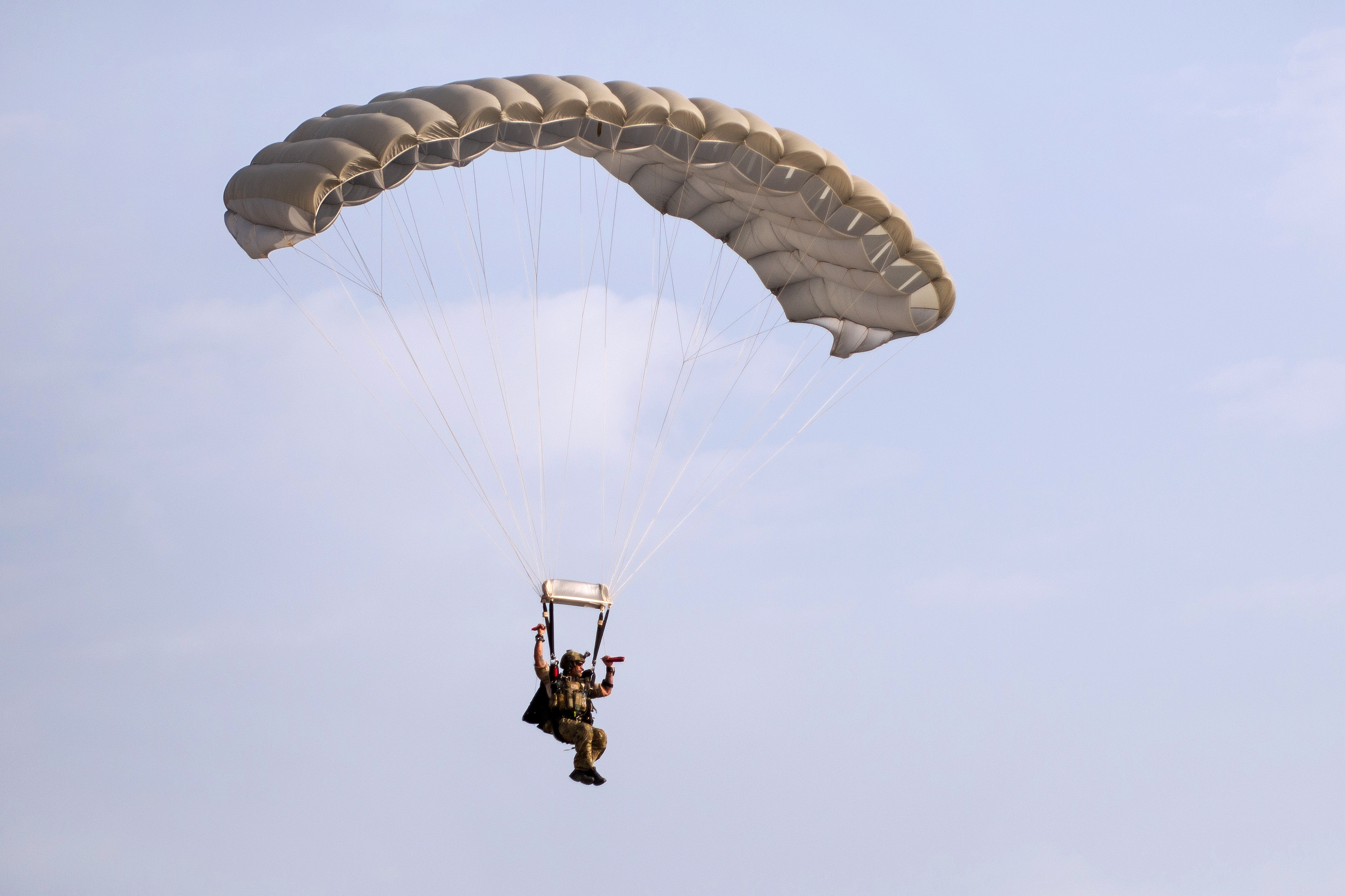 A U.S. airman parachutes to the ground during highaltitude, low