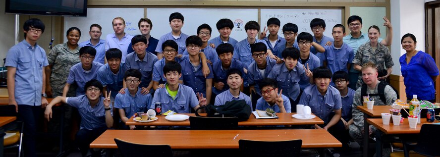 Students from the Cheonan High School podcast club and Airmen from Osan Air Base, South Korea, gather for a group photo in Cheonan, South Korea, July 10, 2015. The Airmen visited the school with American snacks sent from students at Warren Academy, McMinnville, Tenn. The students from Warren Academy previously tried Korean snacks and wanted to see the reactions of Korean students. The cultural exchange was coordinated by Staff Sgt. Thomas Wilson, 51st Fighter Wing command post emergency actions controller, whose mother teaches at Warren Academy. (U.S. Air Force photo/Senior Airman Kristin High)