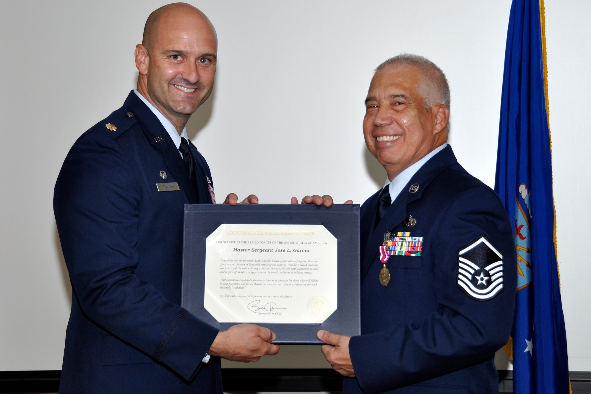 U.S. Air Force Maj. Brian Plauche, 307th Aircraft Maintenance Squadron commander, presents Master Sgt. Jose Garcia, 307th AMXS mechanic, with his certificate of retirement at Barksdale Air Force Base, La., July 11, 2015.  In addition to his military service, Garcia worked as an Air Reserve Technician in the unit.  (U.S. Air Force photo by Tech. Sgt. Ted Daigle/Released)