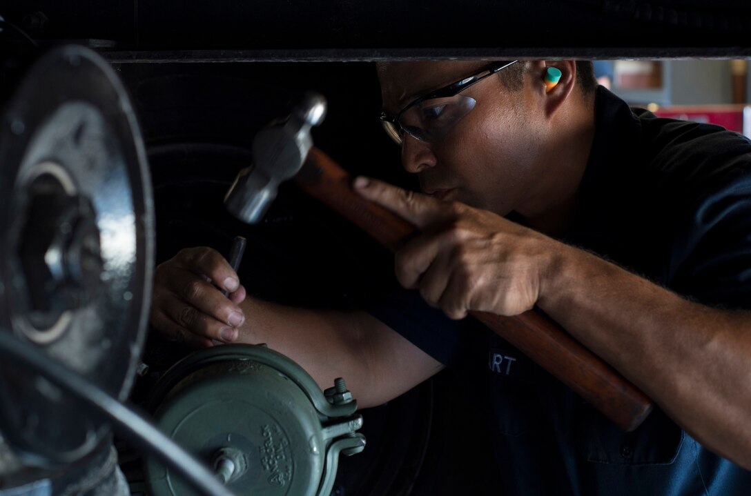 Hart Arbilera, 7th Logistic Readiness Squadron fire and refueling maintenance, works on an airbrake system July 30, 2015, at Dyess Air Force base, Texas. Ricky Bishop, View Volunteer Fire Department fire chief and Taylor County sheriff, took the truck to several civilian mechanics to estimate how much it would cost for repairs to the truck. Because of the age of the vehicle, most turned him away. Several Airmen in the FARM shop had experience with the airbrake system, allowing them to help the station get its most important truck up and running. (U.S. Air Force photo by Senior Airman Peter Thompson/Released)