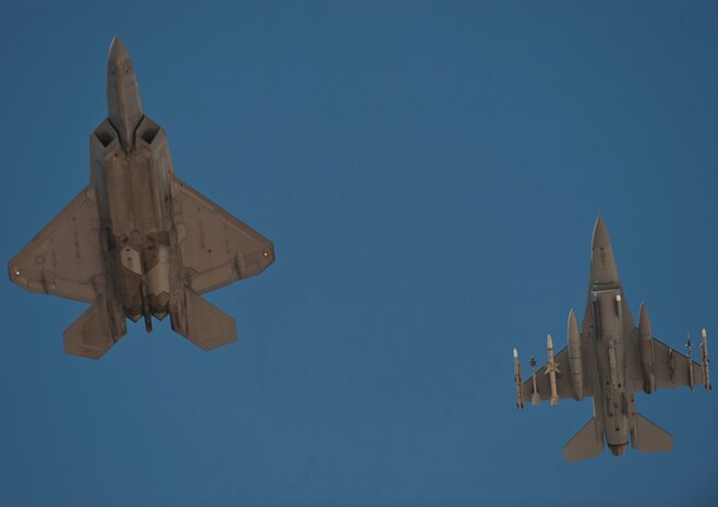 An F-22 Raptor and F-16 Fighting Falcon fly during a Red Flag 15-3 sortie at Nellis Air Force Base, Nev., July 17, 2015. Red Flag involves a variety of attack, fighter, bomber, reconnaissance, electronic warfare, airlift support and search and rescue aircraft. (U.S. Air Force photo by Staff Sgt. Siuta B. Ika)