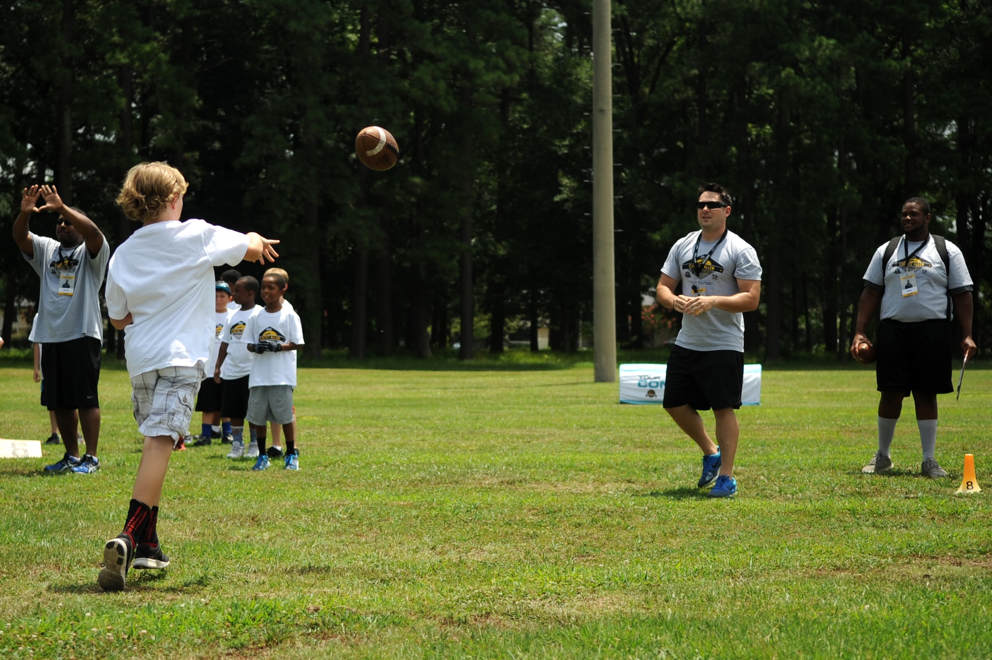 A young athlete practices passing drills with a volunteer coach during a National Football League ProCamp, July 16, 2015, at Seymour Johnson Air Force Base, North Carolina. More than 100 children turned out for the two-day camp. (U.S. Air Force photo/Senior Airman Ashley J. Thum)