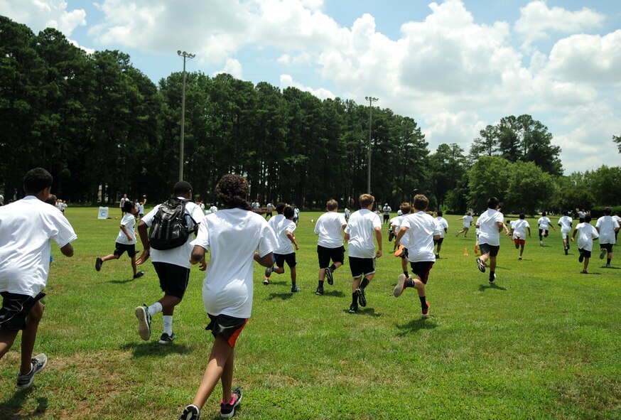 Children run to join their designated teams during a National Football League ProCamp, July 16, 2015, at Seymour Johnson Air Force Base, North Carolina. The camp began with a “draft,” where children were divided into groups named for teams the camp’s guest athlete and Pittsburgh Steelers defensive back, Cortez Allen, had played for. (U.S. Air Force photo/Senior Airman Ashley J. Thum)