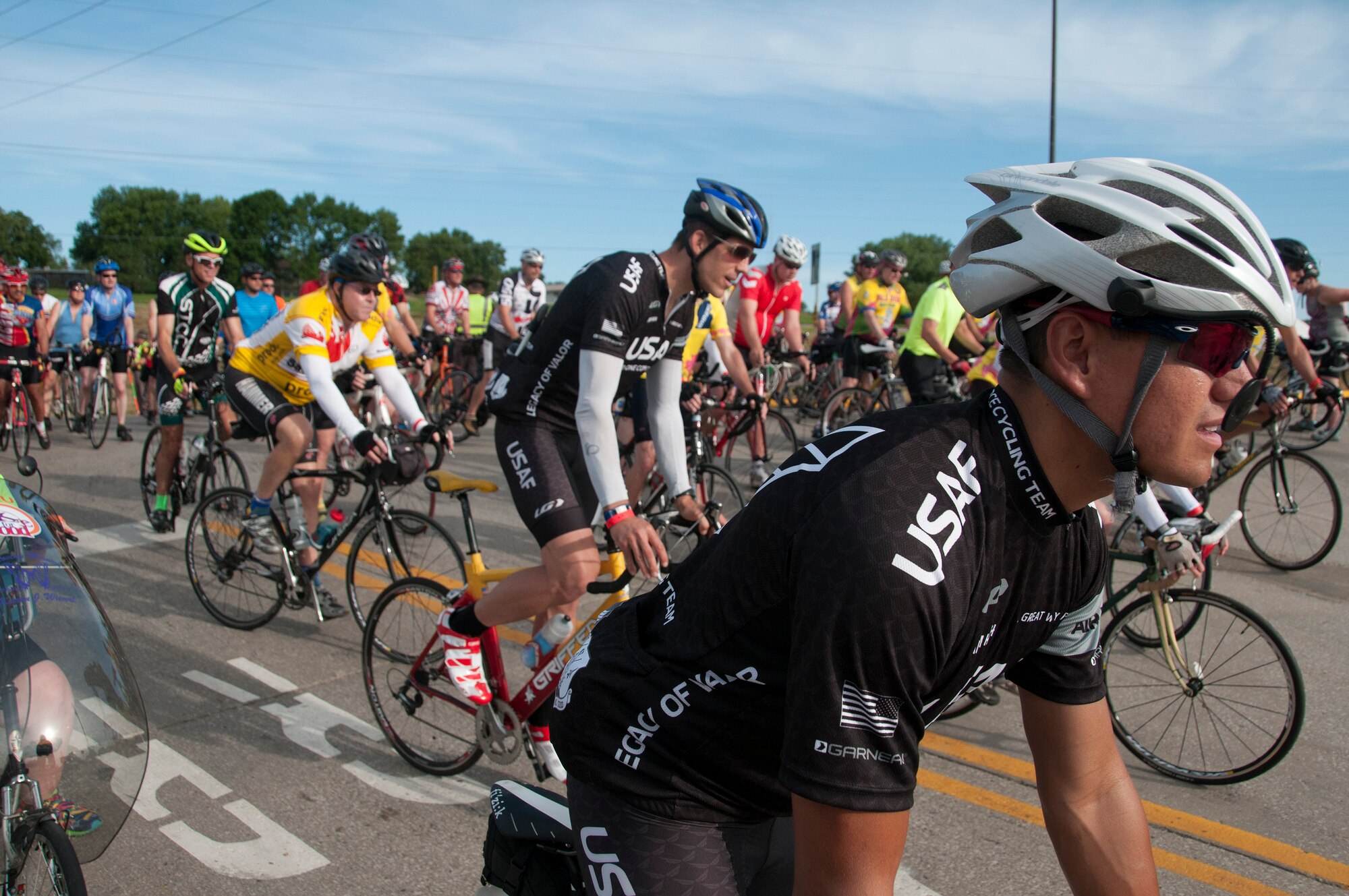 Air Force cycling team members resume riding after waiting for a freight train during the “Registers Annual Great Bike Ride Across Iowa” (RAGBRAI) in Sioux City, Iowa, on July 19, 2015. RAGBRAI participants will travel nearly 500-miles during the weeklong event, beginning in the western side of the state in Sioux City and ending in the Quad Cities in Davenport, Iowa, along the Mississippi river.
(U.S. Air National Guard Photo by: Tech Sgt. Oscar Sanchez/185th ARW Wing Public Affairs Released)

