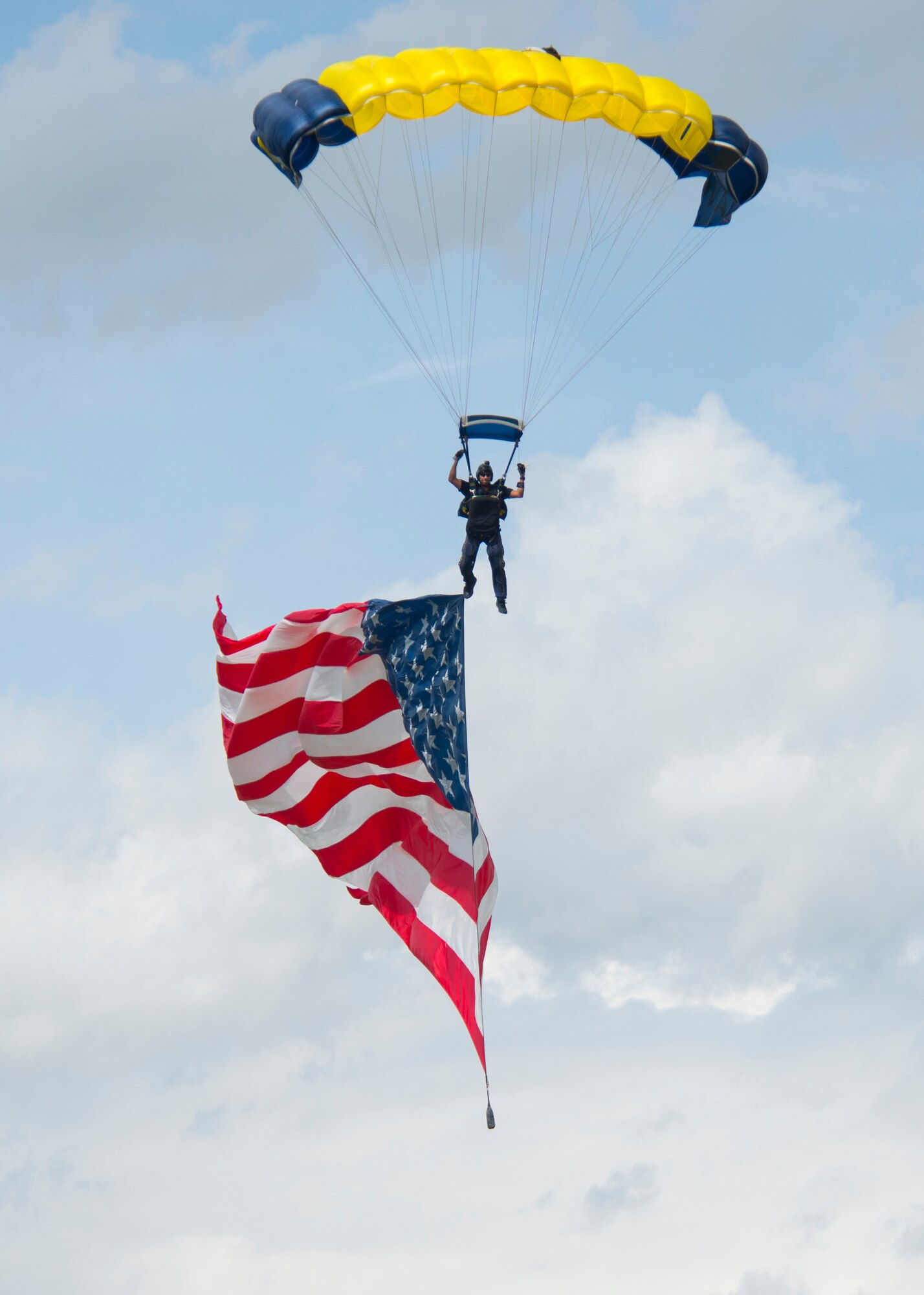 Navy Petty Officer 1st Class Victor Maldonado, guides himself and the U.S. flag in for a landing on F.E. Warren Air Force Base, Wyo., July 18, 2015. Maldonado and his teammates jumped from a C-130 Hercules and landed on F.E. Warren during the base's open house, Fort D.A. Russell Days. (U.S. Air Force photo by Senior Airman Jason Wiese)