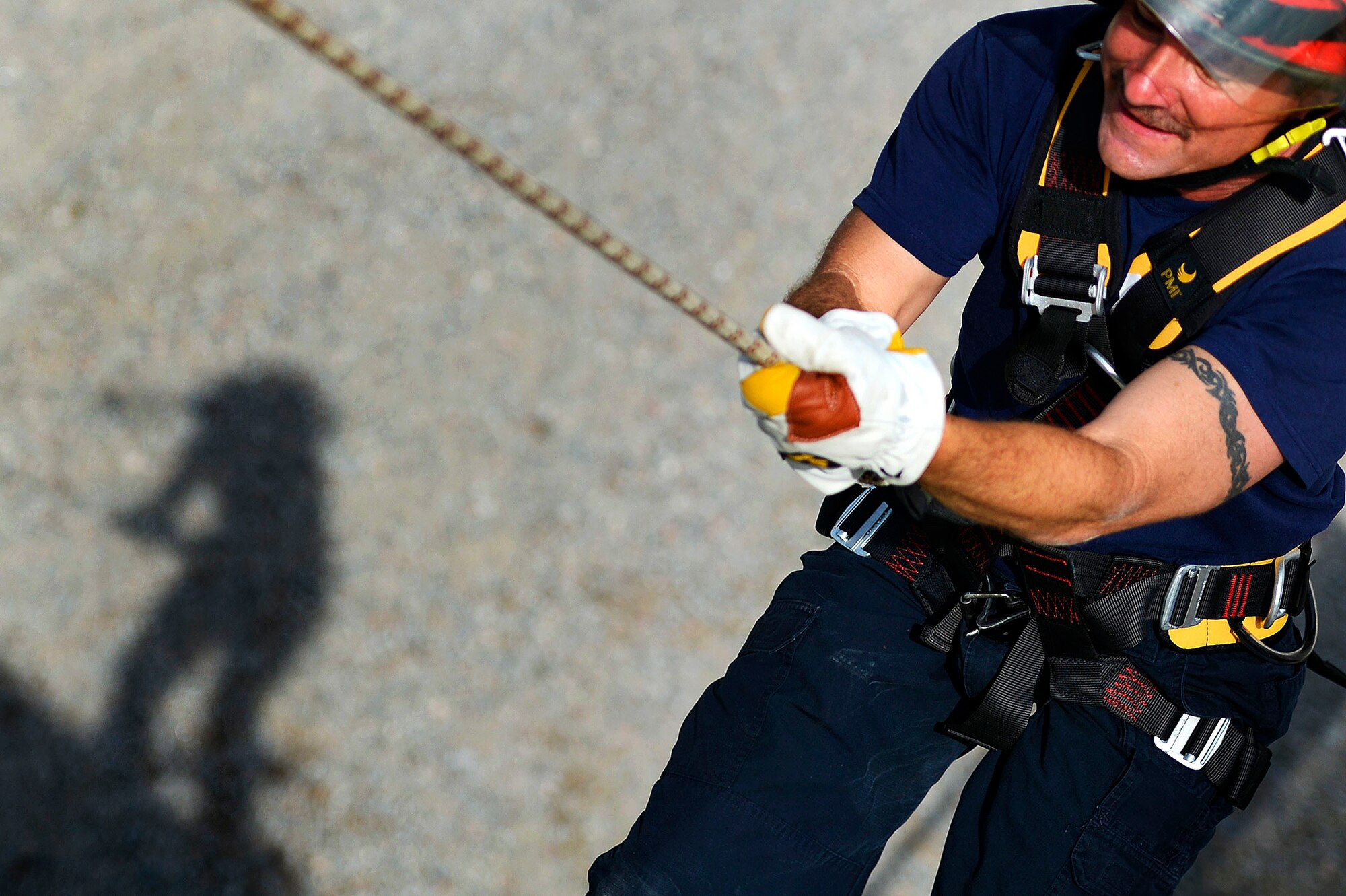 A Sumter Fire Department fireman repels down the structural burn tower at Shaw Air Force Base, S.C., July 13, 2015. Knowledge and experience gained by high-angle rope training could be used when rescuing a person that is at a lower elevation than the firefighter. (U.S. Air Force photo by Senior Airman Jensen Stidham/Released)