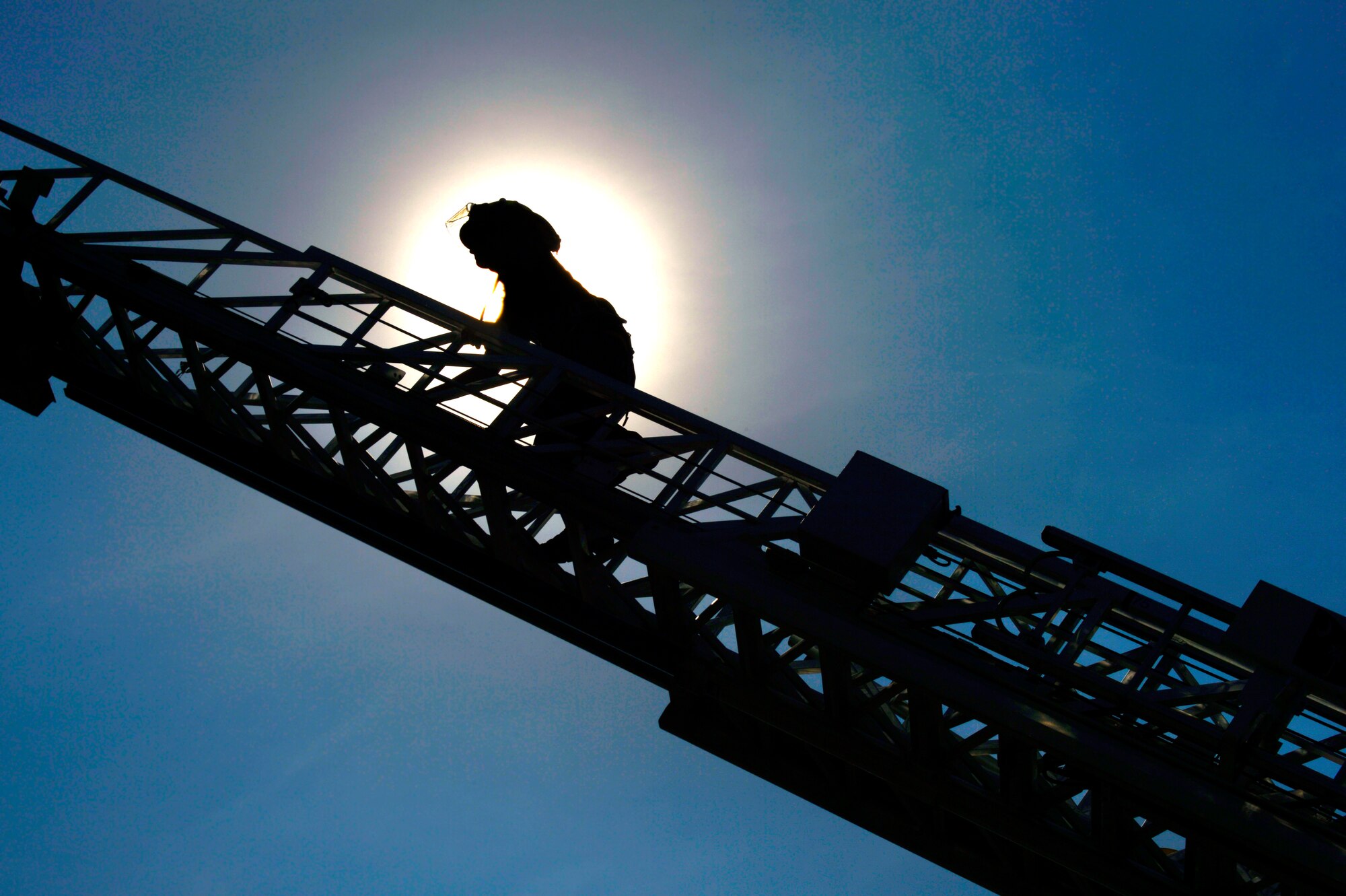 A Shaw Fire Department firefighter climbs up a rescue ladder at the fire training grounds, Shaw Air Force Base, S.C., July 20, 2015. Firefighters practiced high-angle rope training on the structural burn tower to prepare for high-elevation rescues. (U.S. Air Force photo by Jensen Stidham/Released)