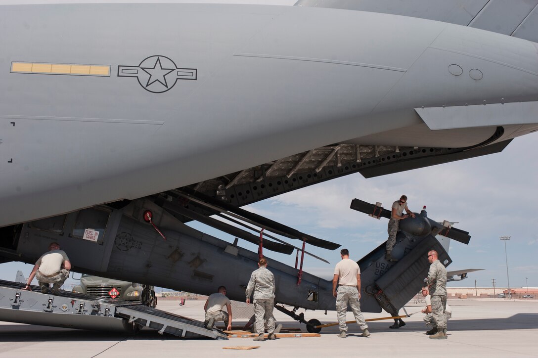 Airmen assigned to the 823rd Maintenance Squadron load an HH-60G Pave Hawk onto a C-17 Globemaster III on the flightline near the 99th Logistics Readiness Squadron’s air terminal at Nellis Air Force Base, Nev., July 14, 2015. Air terminal Airmen usually load and unload cargo from aircraft, but Airmen in HH-60G squadrons are specifically trained on how to load a Pave Hawk onto an aircraft. (U.S. Air Force photo by Airman 1st Class Mikaley Towle)