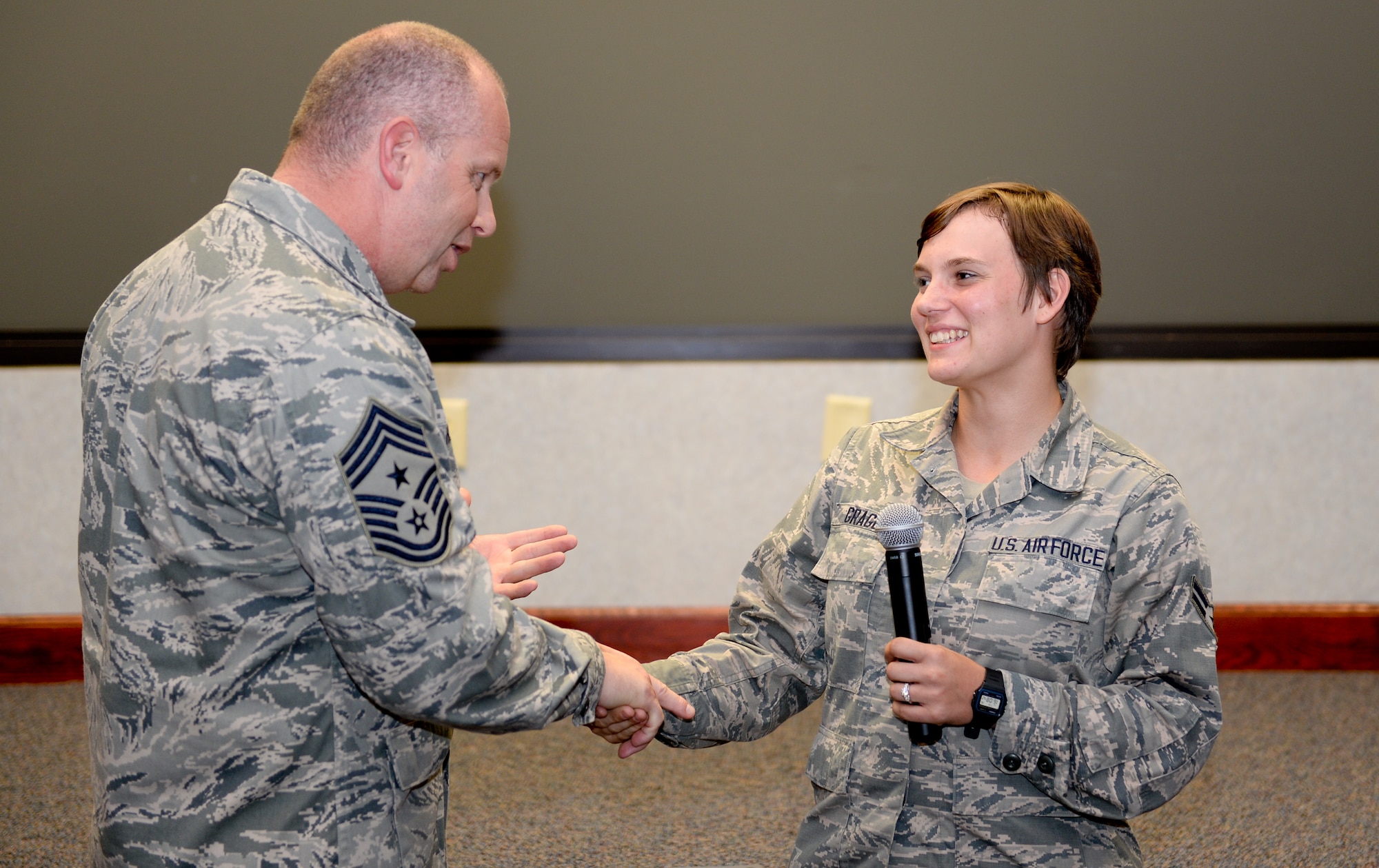 U.S. Air Force Chief Master Sgt. James W. Hotaling, Air National Guard command chief, recognizes Airman 1st Class Willow Gragg, 116th Security Forces Squadron, Georgia Air National Guard, as being one of the 116th Air Control Wing’s newest Guardsman during an enlisted all call at Robins Air Force Base, Ga., July 16, 2015. During his visit, Hotaling conducted two town hall style meetings and met with key enlisted leadership councils and Airmen resiliency representatives. His time with the Airmen focused on sharing his message of a renewed commitment to the profession of arms, health of the force, and recognition of our Airmen and accomplishments. The visit offered the opportunity for Airmen in the wing to meet their top leader, share their concerns and gain perspective from the national level. (U.S. Air National Guard photo by Tech. Sgt. Regina Young/Released)