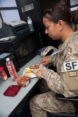 Senior Airman Jessica Flores, 91st Missile Security Forces Squadron flight security controller, eats her lunch in the security control center at the Bravo-01 Missile Alert Facility near Ruso, N.D., July 1, 2015. Due to their demanding schedules, FSCs are often unable to leave the security control area for meals and as such, eat at their desk while working.  (U.S. Air Force photo/Senior Airman Stephanie Morris)