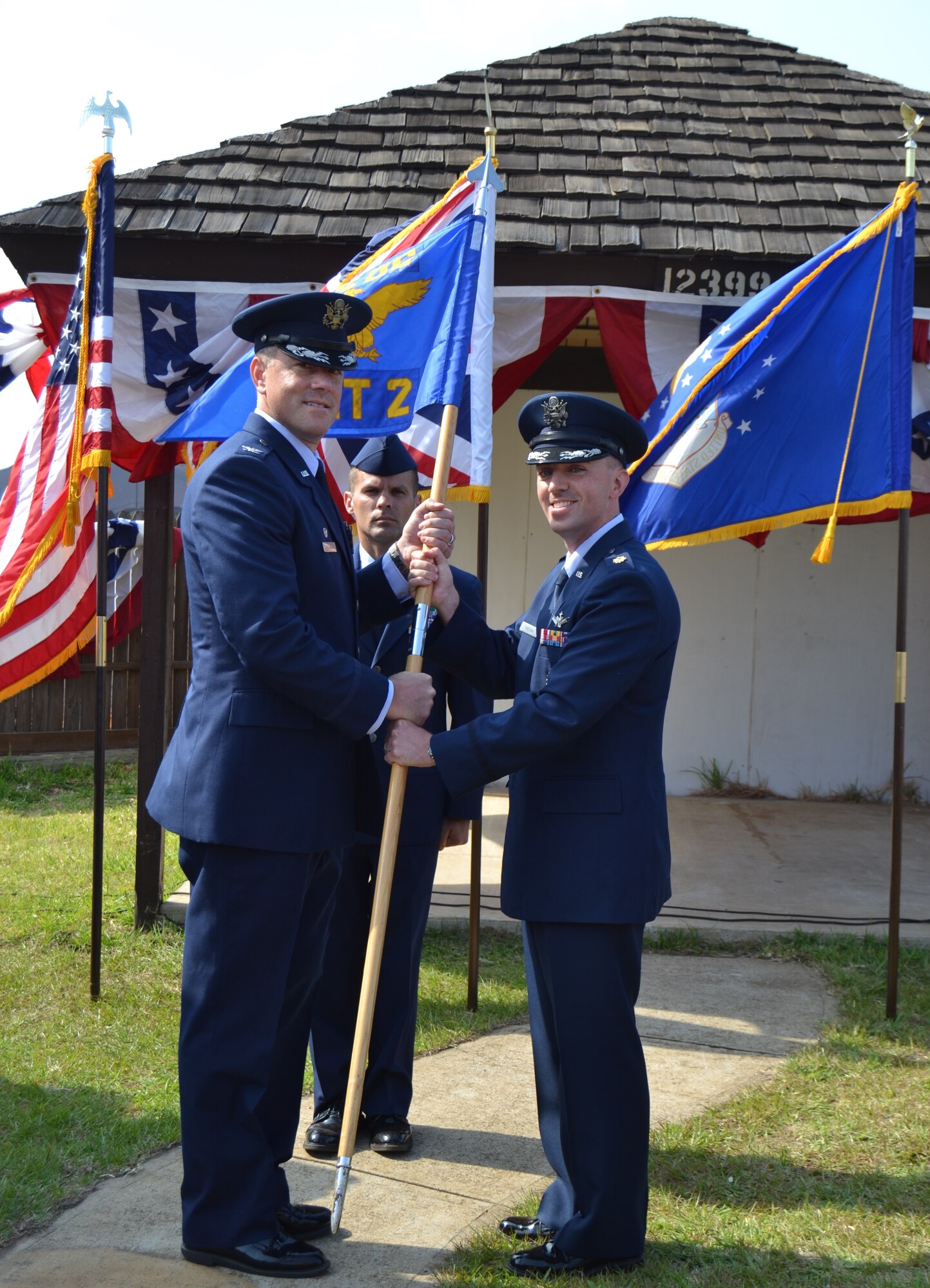 Col. Thomas Falzarano, 45th Operations Group commander, left, presents Maj. Timothy Sheehan, 45th Operations Group Detachment 2 commander, with the guidon during a change of command ceremony at Ascension Auxiliary Airfield, Ascension Island, South Atlantic Ocean, July 7, 2015. Changes of command are a military tradition representing the transfer of responsibilities from the presiding officials to the upcoming official. (Courtesy photo)