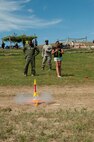 2nd Lt. Cornelius Hall, 740 Missile Squadron missile combat crew deputy, watches as a participant in the Minot outreach event makes her model rocket lift off at New Town, N.D., July 16, 2015. Participants at the event made and shot off their own model rockets donated by Minot Air Force Base to help give an idea of what the 91st Missile Wing does. (U.S. Air Force photo/Airman 1st Class Christian Sullivan)