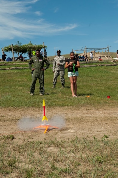 2nd Lt. Cornelius Hall, 740 Missile Squadron missile combat crew deputy, watches as a participant in the Minot outreach event makes her model rocket lift off at New Town, N.D., July 16, 2015. Participants at the event made and shot off their own model rockets donated by Minot Air Force Base to help give an idea of what the 91st Missile Wing does. (U.S. Air Force photo/Airman 1st Class Christian Sullivan)