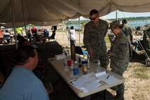 Staff Sgt. Ian and Heather Veldhouse, 5 Munitions Squadron members, demonstrate ammunition examples at a Minot outreach event, New Town, N.D., July 16, 2015. Participants of the outreach event received knowledge on what Minot Air ForceBase’s mission is. (U.S. Air Force photo/Airman 1st Class Christian Sullivan)