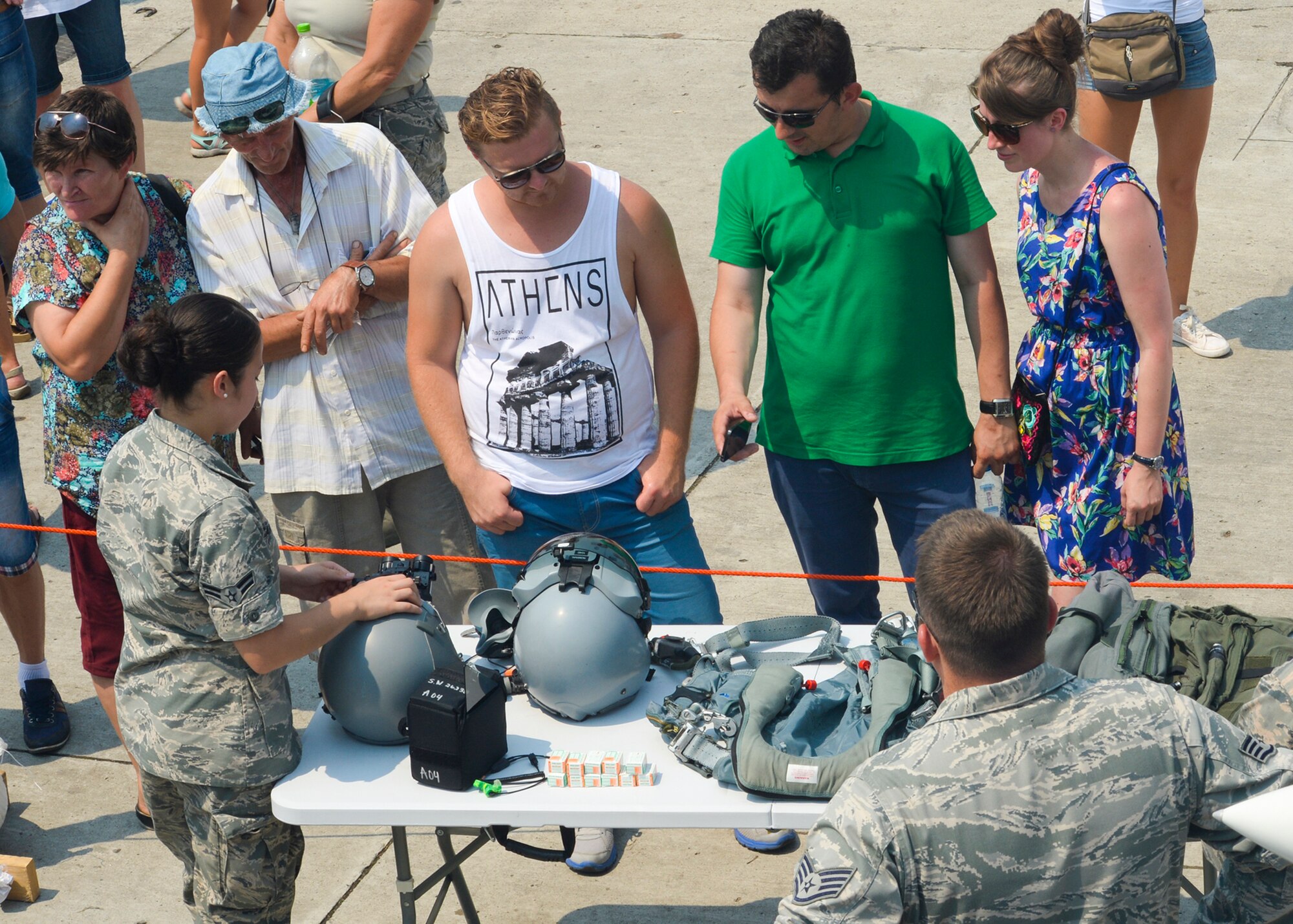 U.S. Air National Guard Airmen from the 123rd Expeditionary Fighter Squadron answer questions from Romanians about flight equipment during the 2015 Campia Turzii Air Show July 19, 2015, at Campia Turzii, Romania. Thousands of spectators witnessed the air show which included the 123rd EFS alongside Romanian air force aircraft. More than 200 Airmen from the 142nd Fighter Wing, Oregon Air National Guard, Portland, Oregon, trained with the Romanian air force as part of a European theater security package of F-15C Eagle fighter aircraft deployed to Romania. (U.S. Air Force photo by Senior Airman Dylan Nuckolls/Released) 
