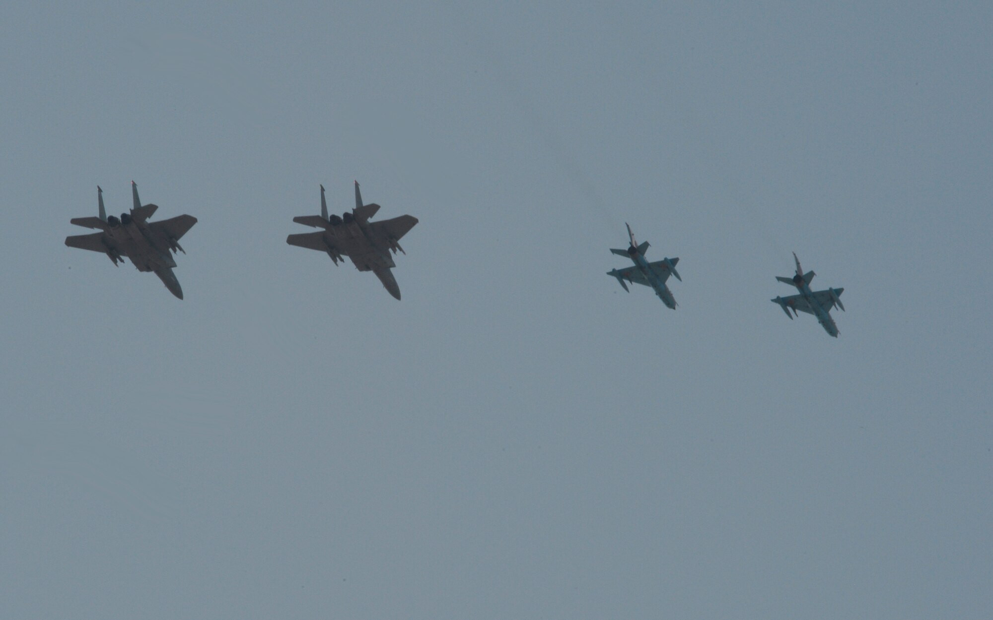 Two U.S. Air National Guard F-15C Eagle fighter aircraft assigned to the 123rd Expeditionary Fighter Squadron and two Romanian MiG-21 fighter aircraft fly over a flightline in formation during the 2015 Campia Turzii Air Show July 19, 2015, at Campia Turzii, Romania. More than 200 Airmen from the 142nd Fighter Wing, Oregon Air National Guard, Portland, Oregon, trained with the Romanian air force as part of a European theater security package of F-15Cs deployed to Romania. (U.S. Air Force photo by Senior Airman Dylan Nuckolls/Released)