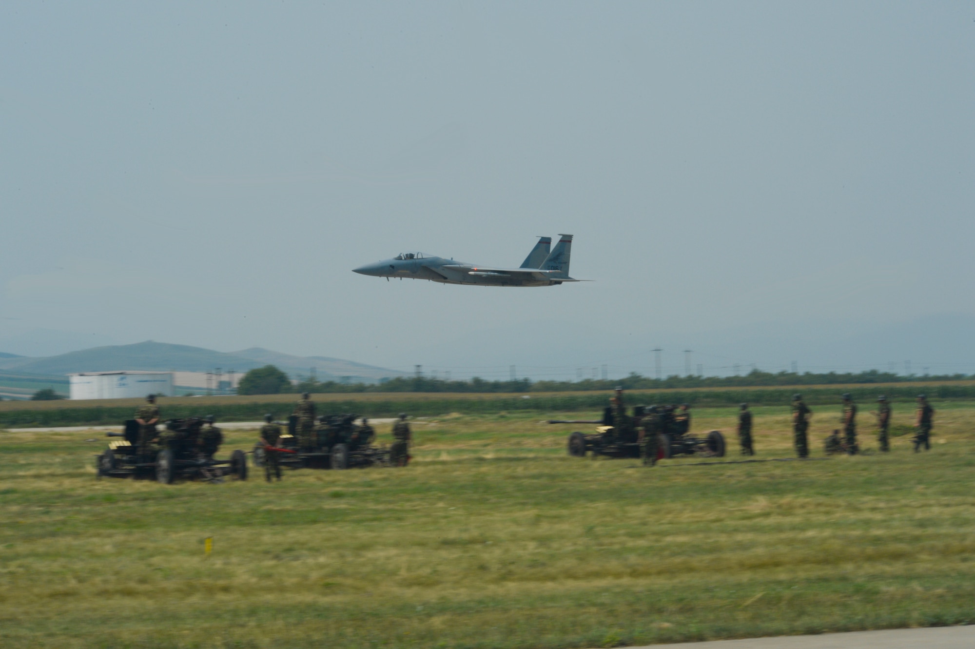 A U.S. Air National Guard F-15C Eagle fighter aircraft assigned to the 123rd Expeditionary Fighter Squadron flies over the flightline as Romanian military members look on during the 2015 Campia Turzii Air Show July 19, 2015, at Campia Turzii, Romania. The aircraft deployed to Romania in support of Operation Atlantic Resolve to bolster air power capabilities while underscoring the U.S.’s commitment to European security and stability. (U.S. Air Force photo by Senior Airman Dylan Nuckolls/Released)