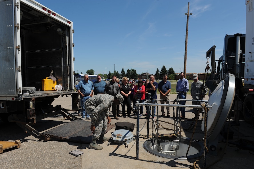 1st Lt. Christophus Trotter, 91st Missile Maintenance Squadron, training flight commander, explains the responsibilities of missile maintainers to members of the Minot community, at the missile trainer facility at Minot Air Force Base, N.D., July 15, 2015. Minot community members toured a missile alert facility as well as a missile trainer facility on base to better understand the 91st Missile Wing’s mission of defending the United States with safe, secure nuclear-capable intercontinental ballistic missiles, ready to immediately put bombs on target. (U.S. Air Force photo/Senior Airman Kristoffer Kaubisch) 