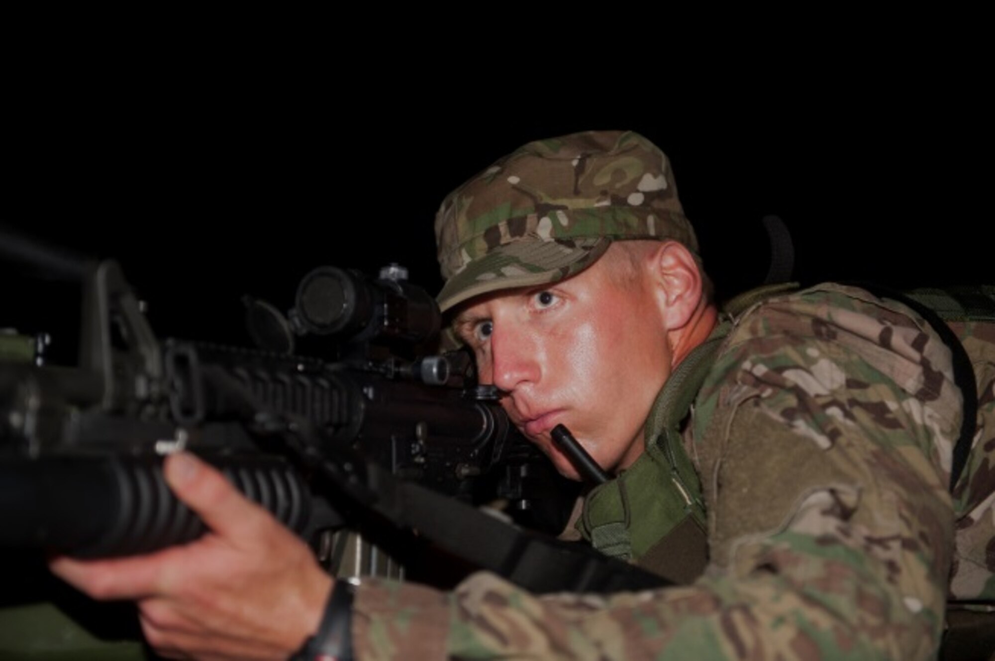Airman 1st Class Joshua Roberts, 5th Security Forces Squadron ranger assessment course trainee, guards the perimeter of a rally point after a night-raid exercise for the ranger assessment course at Minot Air Force Base, N.D., July 17, 2015. Roberts is participating in an exercise of the ranger course that consists of a ruck to the objective check point, leadership and planning skills, a fire fight with armed and dangerous enemies and a recovery of stolen American cryptic devices. (U.S. Air Force photo/Airman 1st Class Christian Sullivan)