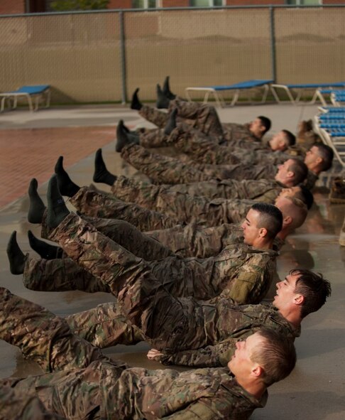 Airmen perform calisthenics before performing a combat water survival assessment during a ranger assessment course at Minot Air Force Base, N.D., July 15, 2015. To pass the course Airmen are required to complete a Ranger Physical Assessment, combat water survival assessment, 12 –mile foot march and day and night combined land navigation. (U.S. Air Force photo/Airman 1st class Christian Sullivan)