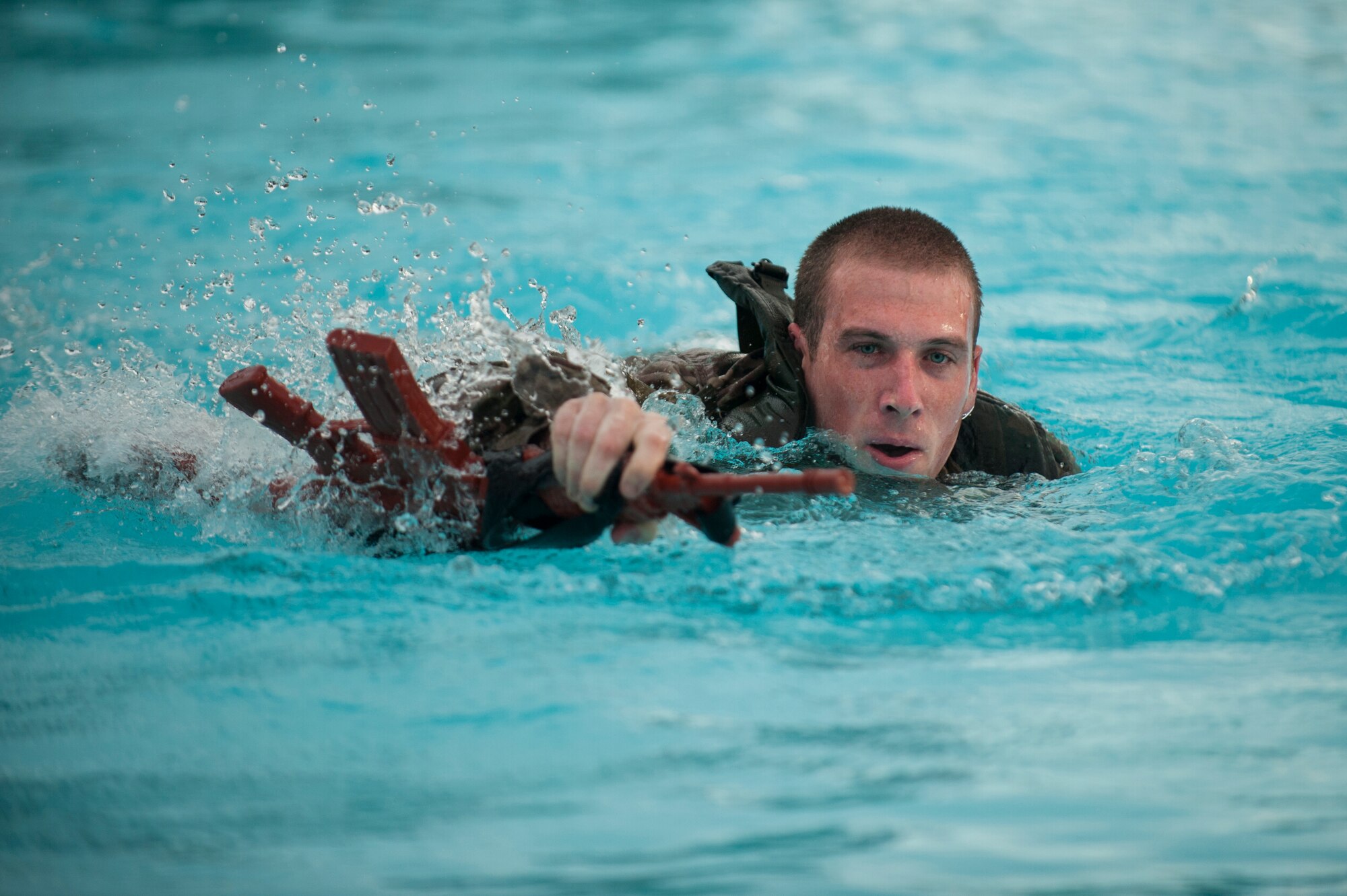 Airman 1st Class Nicholas Harp, 5th Security Forces Squadron ranger assessment course trainee, swims across the pool in full ruck gear during a ranger assessment course at Minot Air Force Base, N.D., July 15, 2015. To pass the course Harp is required to complete a Ranger Physical Assessment, combat water survival assessment, 12 –mile foot march and day and night combined land navigation. (U.S. Air Force photo/Airman 1st class Christian Sullivan)