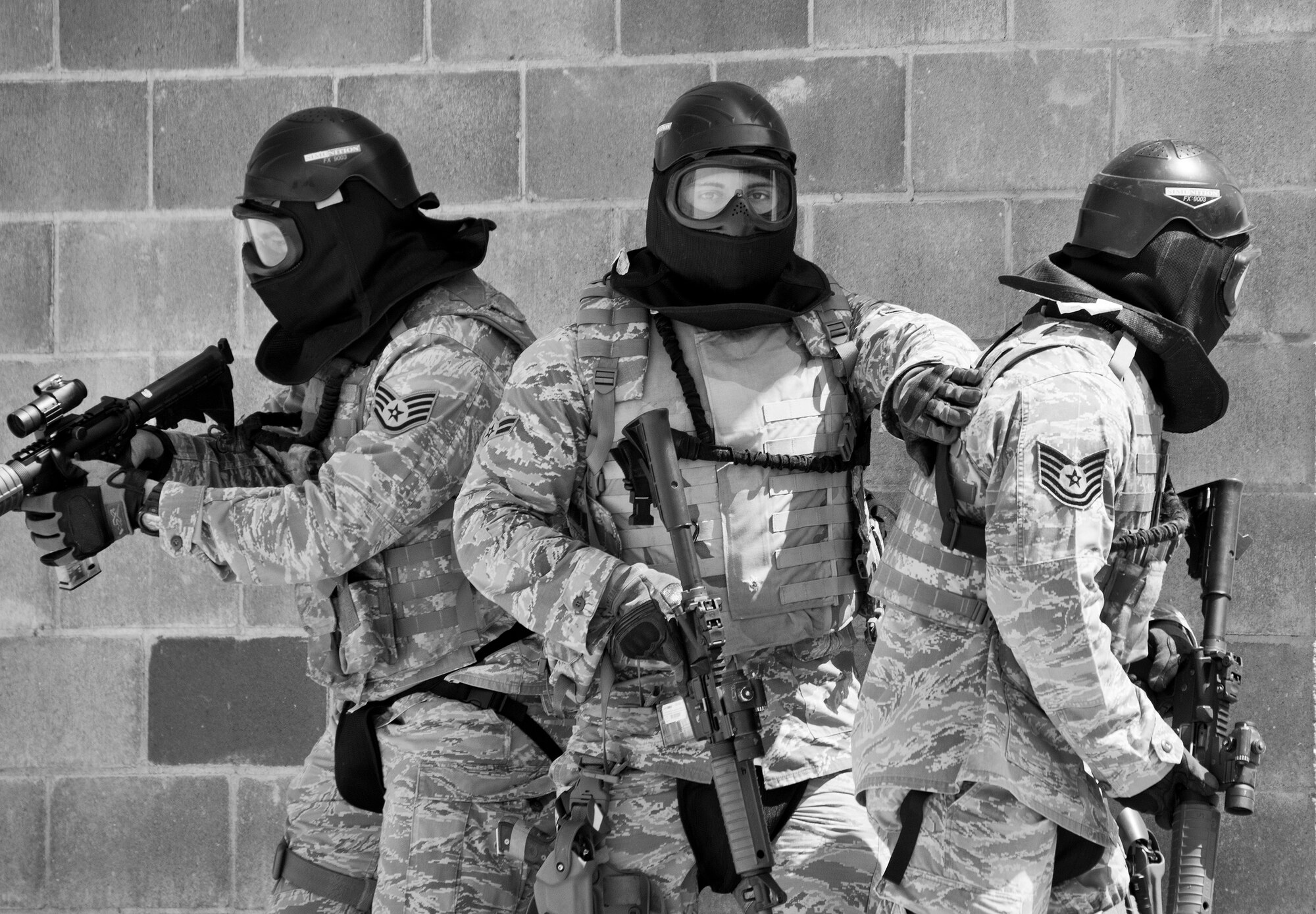 A team of 96th Security Forces Squadron Airmen prepare to enter a building during a shoot, move and communicate drill in June at Eglin Air Force Base, Fla.  The mandatory training requirement is in addition to annual weapons qualification training.  The exercise consists of Airmen firing simmunition ammo while advancing toward, away from and to the side of a target.  This is followed by a building sweep and clear drill.  The Defenders perform the highly kinetic training at Eglin’s Base Tango range.  The range was previously used for security forces pre-deployment training.  (U.S. Air Force photo/Samuel King Jr.)