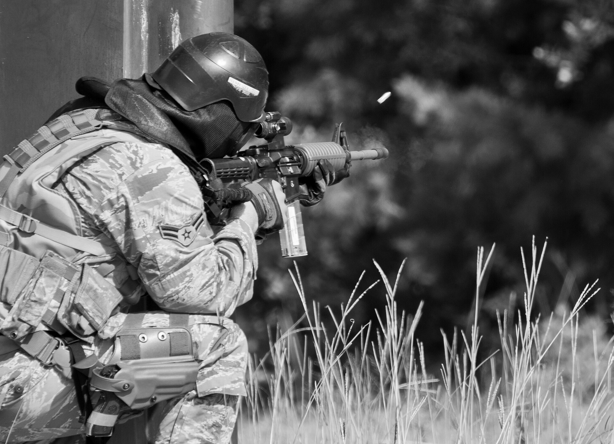 A simmunition round pops out of 96th Security Forces Squadron Airman’s M-4 rifle as he fires downrange during a shoot, move and communicate drill in June at Eglin Air Force Base, Fla.  The mandatory training requirement is in addition to annual weapons qualification training.  The exercise consists of Airmen firing simmunition ammo while advancing toward, away from and to the side of a target.  This is followed by a building sweep and clear drill.  The Defenders perform the highly kinetic training at Eglin’s Base Tango range.  The range was previously used for security forces pre-deployment training.  (U.S. Air Force photo/Samuel King Jr.)