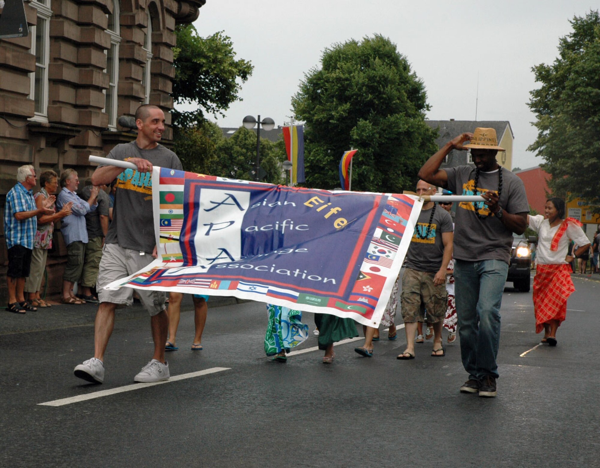 Spangdahlem Air Base's Asian Pacific American Heritage Association members carry a banner during the City of Bitburg's Folklore festival in Bitburg, Germany, July 12, 2015. Observers participated in the events in commemoration of the city's 1,300th anniversary and the Folk Festival's 50th anniversary. (U.S. Air Force photo by Iris Reiff/Released)