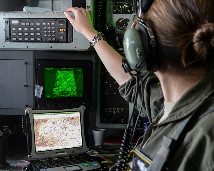Capt. Allison Ahlinger, 36th Airlift Squadron navigator, directs the flight path of a C-130 Hercules at Yokota Air Base, Japan, July 14, 2015. Ahlinger, who assisted in a flight of four C-130s, visually identified landmarks to ensure correct positioning over the drop zone. (U.S. Air Force photos by Airman 1st Class Elizabeth Baker/Released)