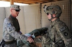 Army Command Sgt. Maj. Richard Burch, the command sergeant major of the Army National Guard, shakes the hand of Army Spc. Vernon Moore, a military policeman and gunner from with Headquarters and Headquarters Company, 1st Squadron, 113th Cavalry Regiment, Task Force Redhorse, a part of the 2nd Brigade Combat Team, 34th Infantry Division, at the entry control point on Joint Combat Outpost Pul-E-Sayad, Afghanistan May 27, 2011. Burch visited the JCOP during a battlefield rotation he conducted with Army Command Sgt. Maj. Raymond Chandler, the command sergeant major of the Army.