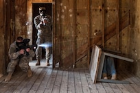 A Soldier with the U.S. Army Reserve 312th Engineer Company, based in Duluth, Minn., fires his M4 rifle paintball gun while an opposing force member hides behind a table during urban operations training and building clearing procedures, April 18, 2015, at Camp Ripley, Minn. The 312th has seen a turnaround in its retention and recruiting based on an atmosphere of caring about each Soldier and their families while providing meaningful and innovative training during each battle assembly. (U.S. Army photo by Timothy L. Hale/Released)