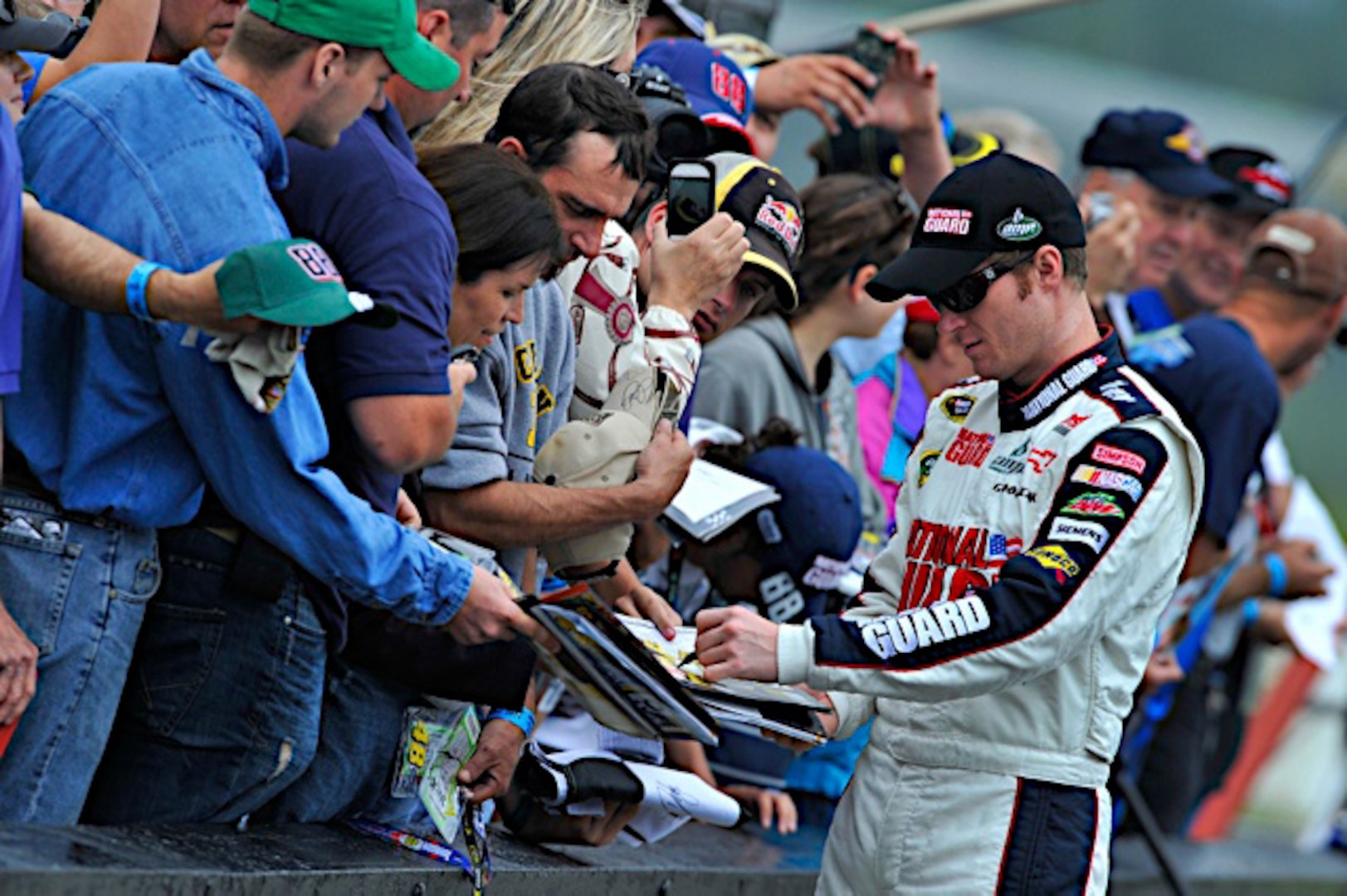 Dale Earnhardt Jr., driver of the No. 88 National Guard NASCAR racecar, stops to sign autographs for fans at Pocono Raceway June 12, 2011 in Long Pond, Pa. Dale Jr. is now only ten points behind the leader in the Sprint Cup series points race after finishing in sixth place Sunday.