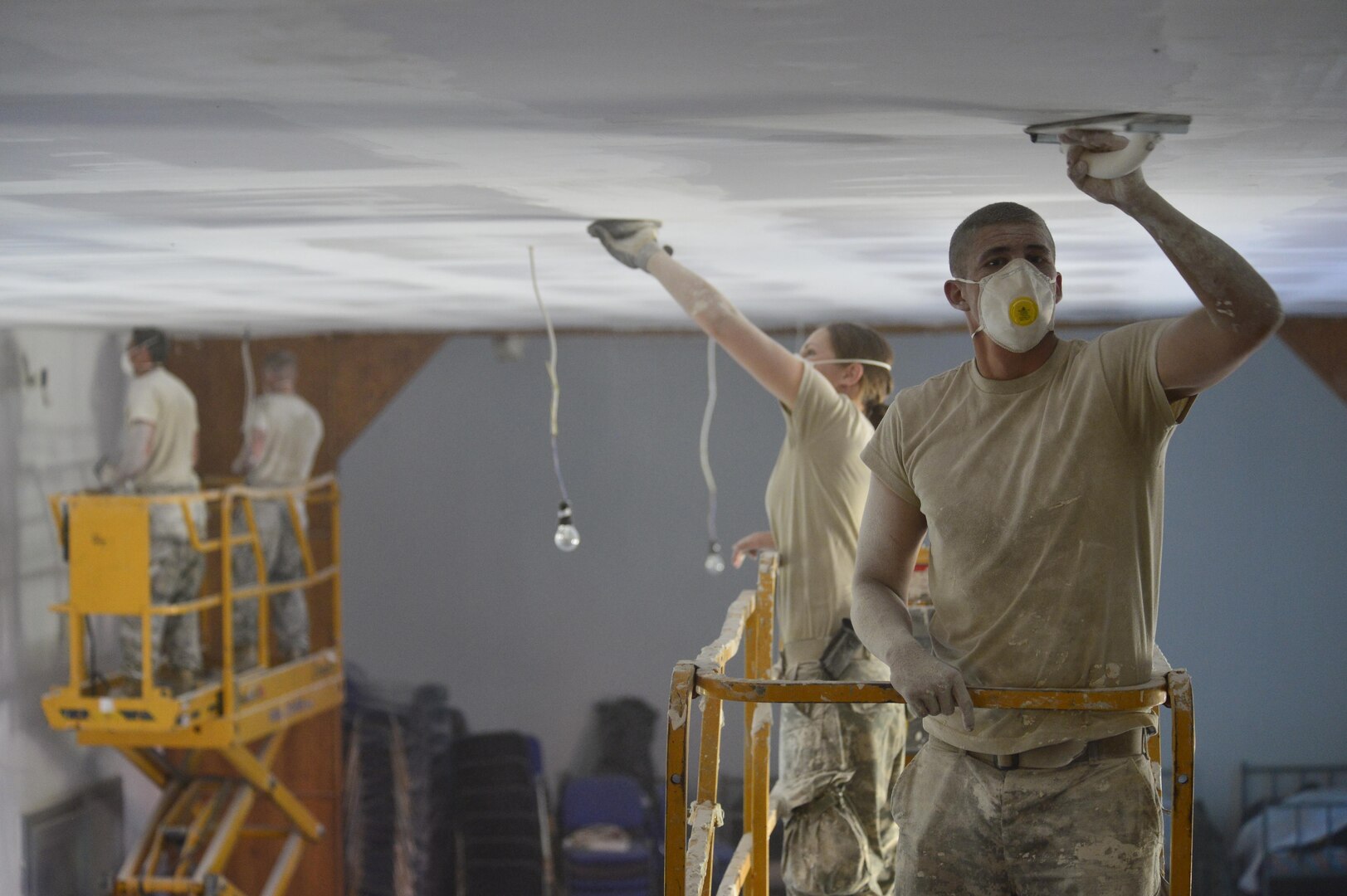 Spc. Christopher Anderson, carpentry/masonry specialist, sands and smooths plaster on the ceiling. He is with other Soldiers of the 851st Vertical Engineer Company and members of the Croatian Army, Armored Mechanic Brigade, working together for repairs and to rebuild a roof on a damaged community center in the local town of Račinovci, Croatia.  The project is a Humanitarian Civic Assistance project made possible by the U.S. European Command in partnership with the U.S. Embassy in Zagreb, Croatia.