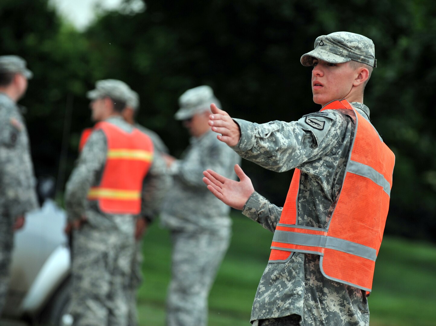 Army Pfc. Thad Buri, Watertown, a service member of the 235th Military Police Company, directs traffic at a traffic control point in Dakota Dunes, June 17, 2011. Buri and other members of the 235th Military Police Company are conducting traffic control and ID checks as local residents return to survey potential damages to their homes caused by the flooding of the Missouri River.