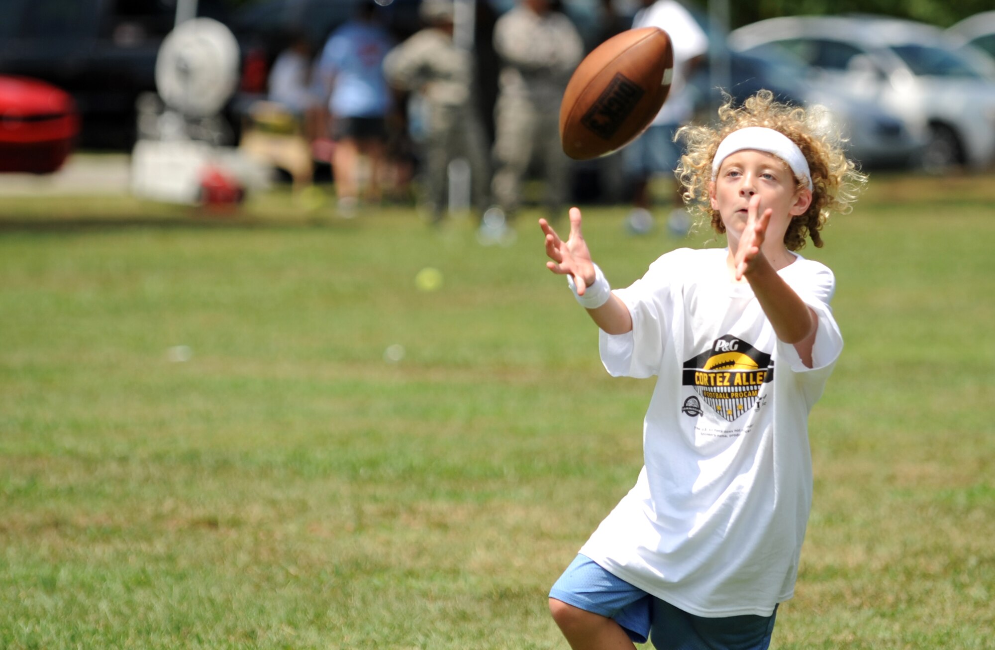 A young athlete lines up to snag a pass during a National Football League ProCamp, July 16, 2015, at Seymour Johnson Air Force Base, N.C. ProCamps are held all over the U.S. and internationally, to give children once-in-a-lifetime skill training with professional athletes. (U.S. Air Force photo/Senior Airman Ashley J. Thum)