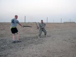 Army Spc. Paul Hanson (left), a convoy escort team gunner with Alpha Company, 1st Combined Arms Battalion, 163rd Infantry Regiment, 4th Sustainment Brigade, 310th Expeditionary Sustainment Command, brings his sword to bear against Army Sgt. John Oglesby, a convoy escort team gunner with Co. A, 1-163 CAB, in “The Pit” on Contingency Operating Base Adder, Iraq. Oglesby has been sparring for about 25 years and shares his hobby with fellow Solders while deployed.