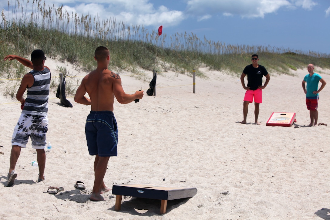 Marines toss bean bags for score during the annual family fun day beach bash at Fort Macon beach, North Carolina, July 17, 2015. Members of Headquarters and Headquarters Squadron, Marine Transport Squadron 1, and their families attended the event.