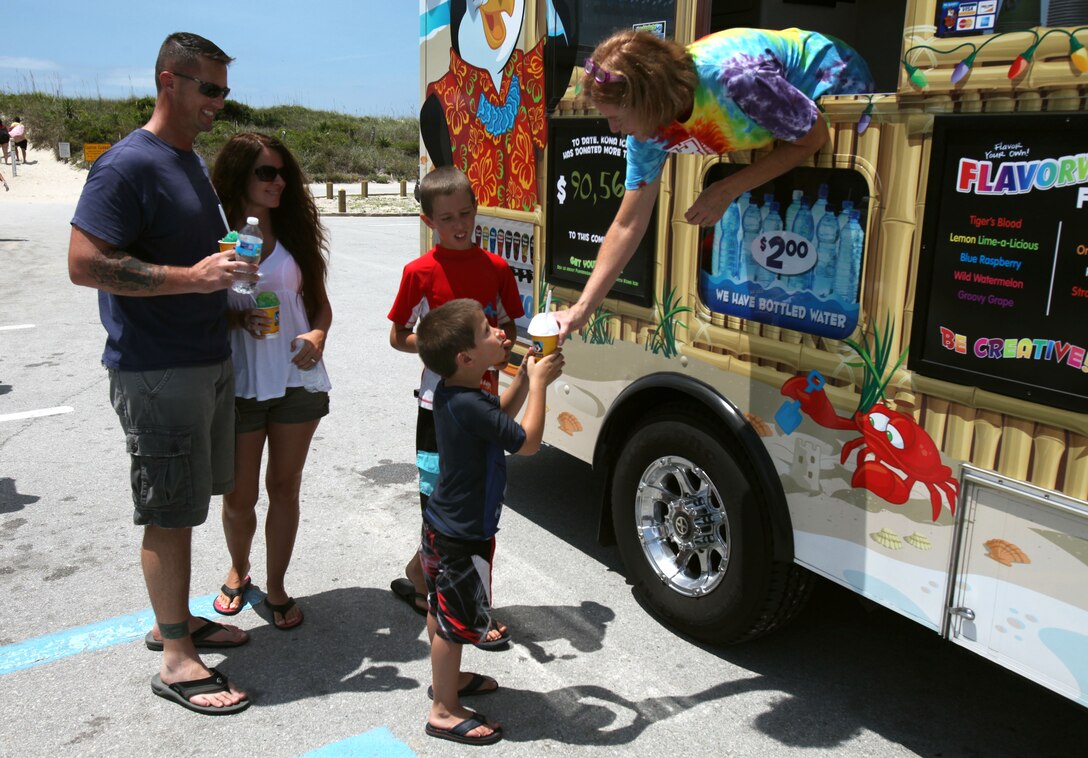 Sgt. Maj. Eric Bauer, the Headquarters and Headquarters Squadron sergeant major at Marine Corps Air Station Cherry Point, his wife, Shelly, and two son, Clayton and Steven, enjoy shaved ice during the annual family fun day beach bash at Fort Macon beach, North Carolina, July 17, 2015. Members of Headquarters and Headquarters Squadron, Marine Transport Squadron 1, and their families attended the event.