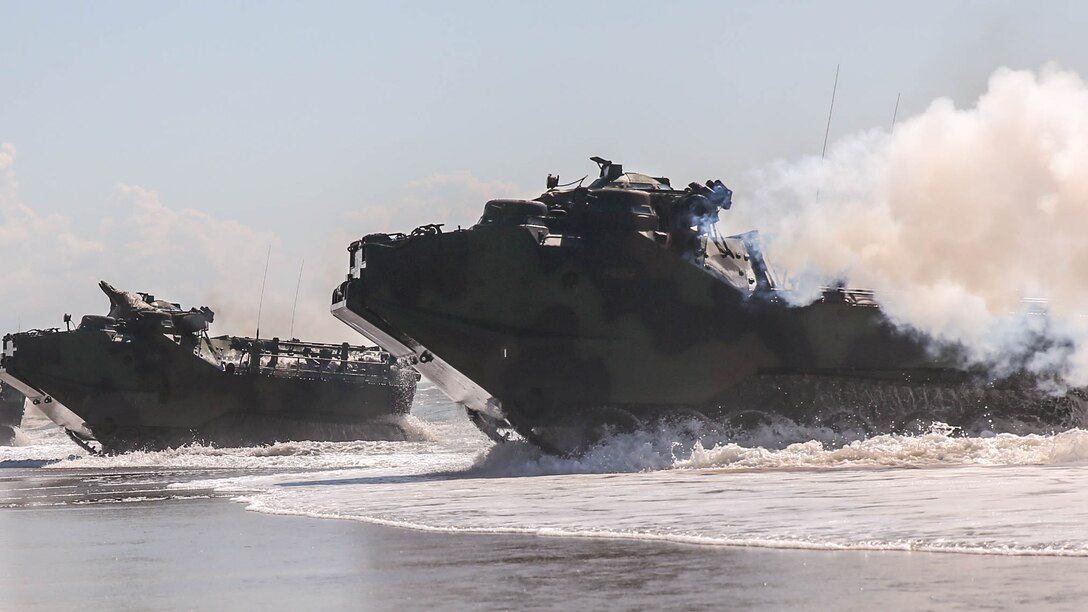 Marines with 2nd Assault Amphibious Battalion, 2nd Marine Division, make landfall in assault amphibious vehicles during amphibious training operations aboard Camp Lejeune, N.C., July 16, 2015. Marines use white smoke canisters during exercises and assaults to conceal ground forces as they leave the AAVs before moving inland.