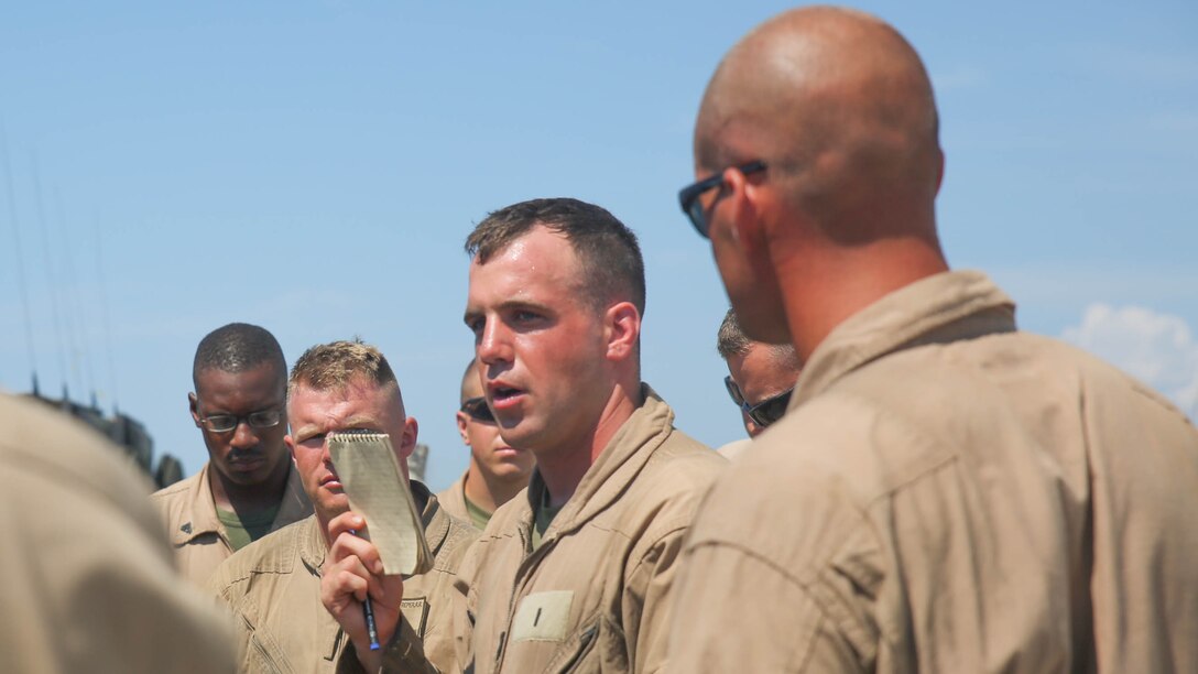 1st Lt. Ian Budge (center), a platoon commander with 2nd Assault Amphibious Battalion, 2nd Marine Division, leads an after-action discussion with Marines in his unit during amphibious training operations aboard Camp Lejeune, N.C., July 16, 2015. The discussion allowed the Marines to reflect on all points of the operation in order to make improvements during future exercises.