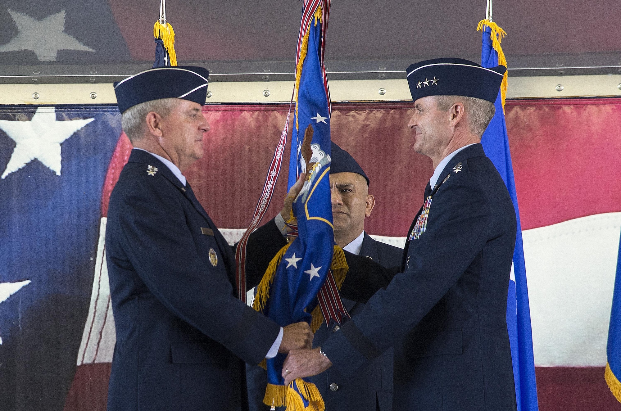 JOINT BASE SAN ANTONIO-RANDOLPH, Texas -- Air Force Chief of Staff Gen. Mark A. Welsh III (left) passes the Air Education and Training Command guidon to Lt. Gen. Darryl Roberson, commander of AETC, during a change of command ceremony at Joint Base San Antonio-Randolph, Texas, July 21, 2015. The change of command ceremony represents the formal passing of responsibility, authority and accountability of command from one officer to another. (U.S. Air Force photo by Johnny Saldivar) 