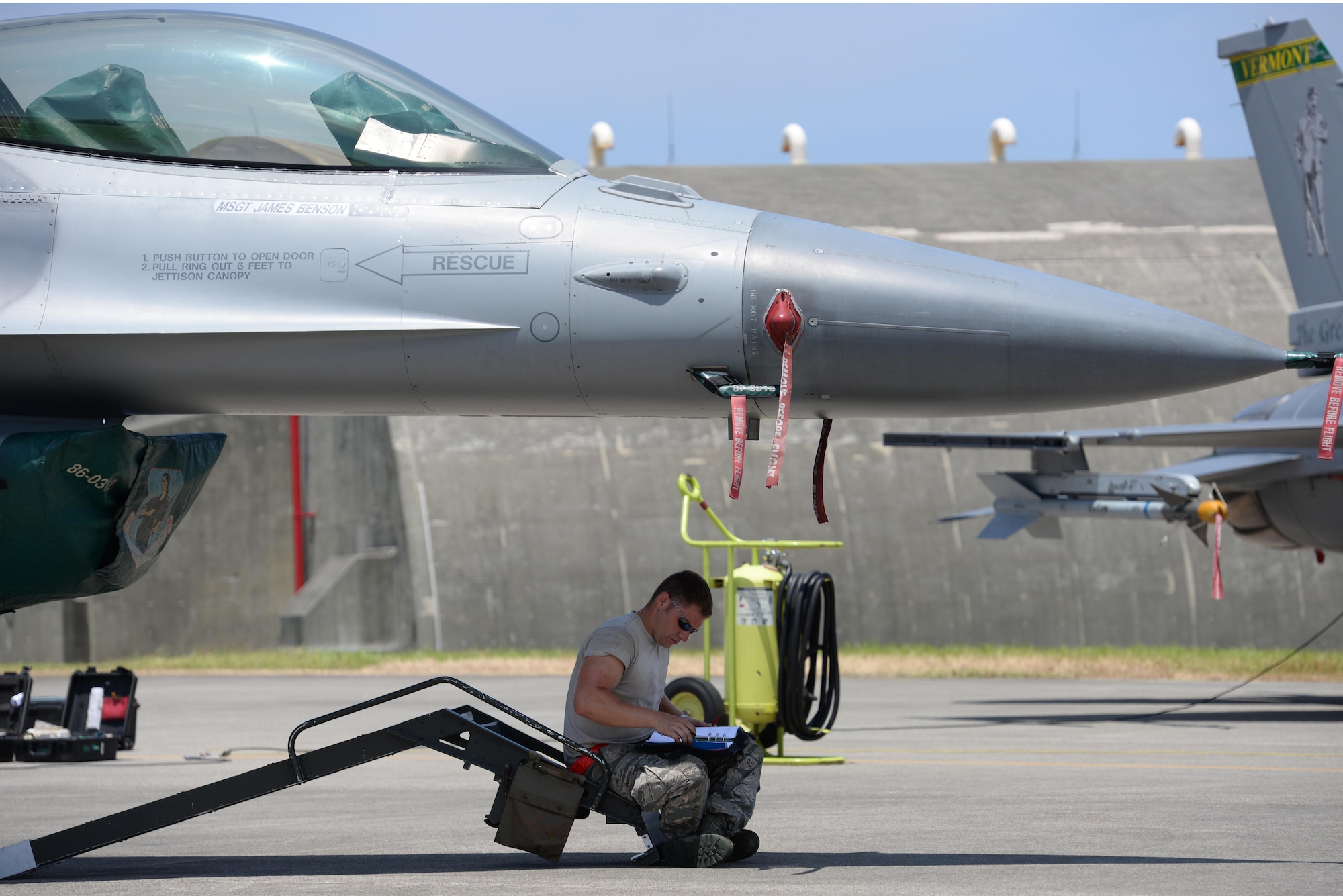 U.S. Air Force Senior Airman Ryan Banneau, 158th Fighter Wing F-16 Fighting Falcon crew chief, fills out a checklist in the shade of an F-16 on Kadena Air Base, Japan, July 16, 2015. The 158th Fighter Wing of Vermont is currently deployed to Kadena as part of a Pacific Command Theater Security Package to enhance regional security in the Indo-Asia-Pacific region and demonstrate the U.S. commitment to stability in the region. (U.S. Air Force photo by Senior Airman Omari Bernard/Released)