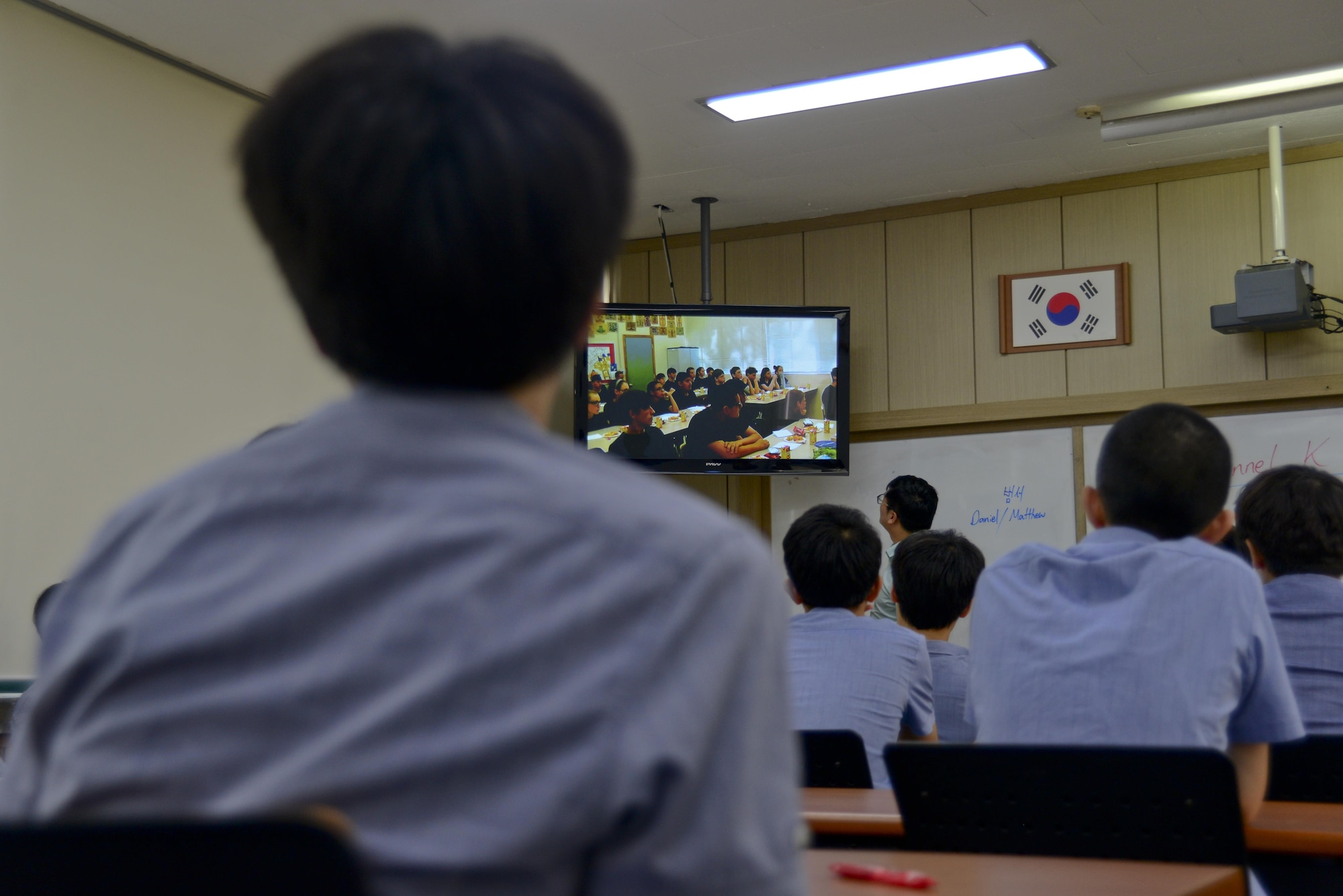 Students from the Cheonan Boys’ High School watch a video from students at Warren Academy, McMinnville, Tennessee, in Cheonan, South Korea, July 10, 2015. An international cultural exchange between the schools was coordinated by U.S. Air Force Staff Sgt. Thomas Wilson, 51st Fighter Wing command post emergency actions controller, whose mother teaches at Warren Academy. The exchange allowed the students from Cheonan to not only try American snacks, but to meet Airmen on a friendly and personal level in understanding the mission of the U.S. Air Force in Korea. (U.S. Air Force photo by Senior Airman Kristin High/Released)

