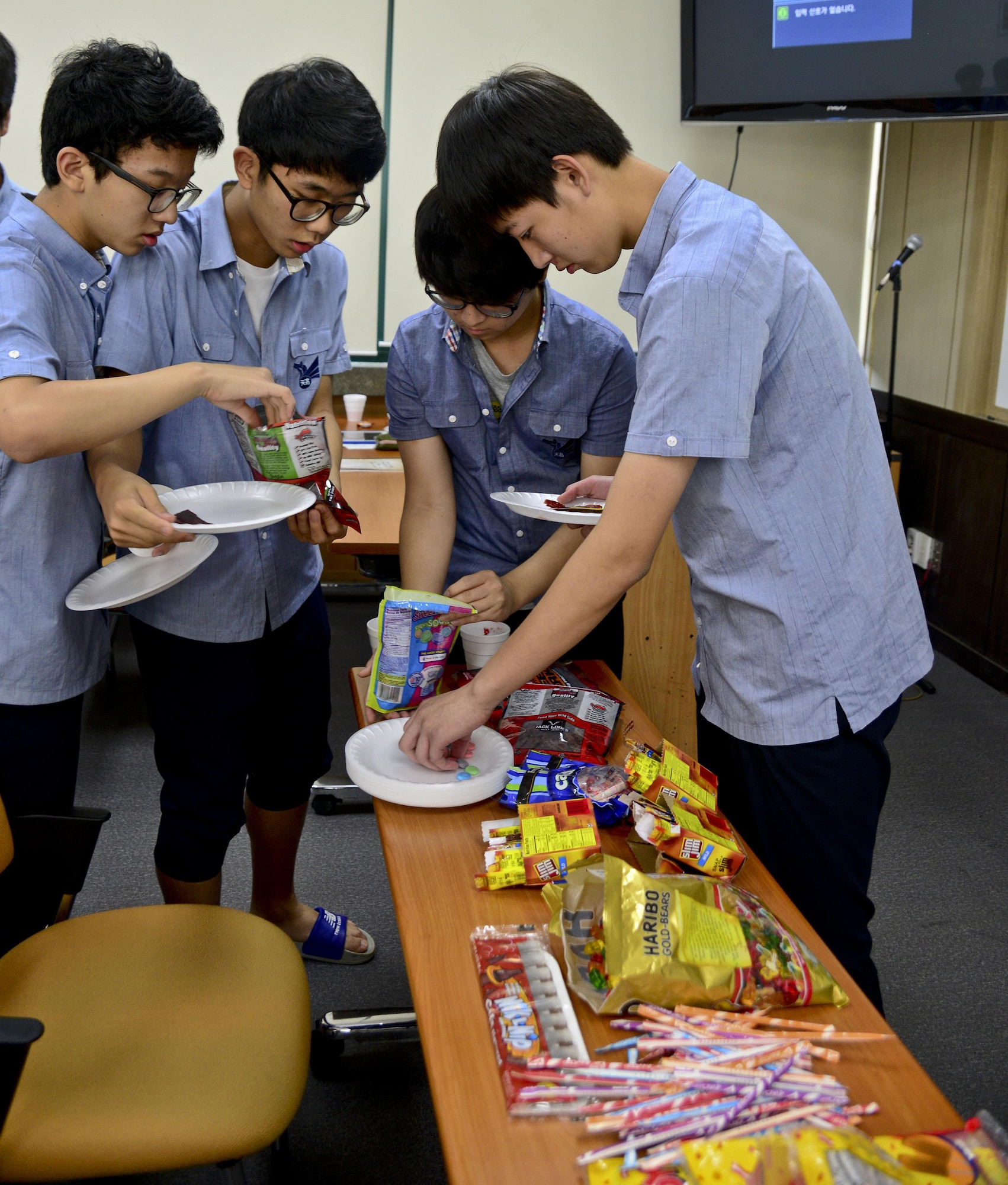 Students from Cheonan High School, Cheonan, South Korea, gather American snacks to try July 10, 2015. The students of the podcast club, “Channel K Radio," tried various American snacks during an international cultural exchange between Cheonan and Warren Academy, McMinnville, Tenn. (U.S. Air Force photo by Senior Airman Kristin High/Released)