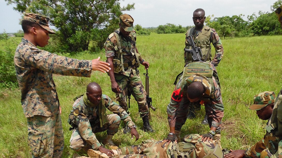 U.S. Marine Cpl. Stephan James, a team leader with Special-Purpose Marine Air-Ground Task Force Crisis Response-Africa, directs Ghanaian soldiers moving a simulated casualty to a litter near Accra, Ghana, June 23, 2015. The Marines and Sailors of SPMAGTF-CR-AF partnered with the Ghanaian army for a month-long security cooperation exercise in infantry skills to help foster a stronger working relationship between the two nations’ militaries. 